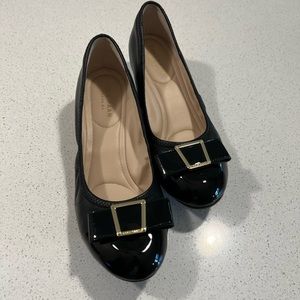 Cole Haan black wedge pump. Black leather with patent toe and bow.